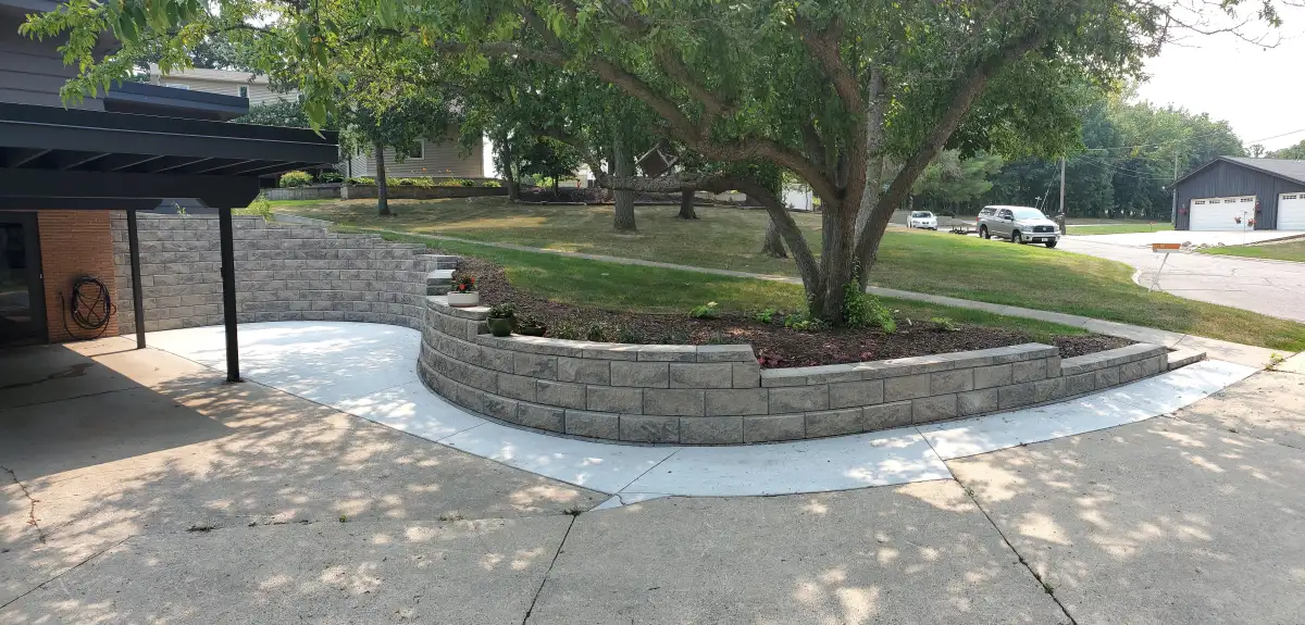 Front yard curved block retaining wall with steps and planting bed