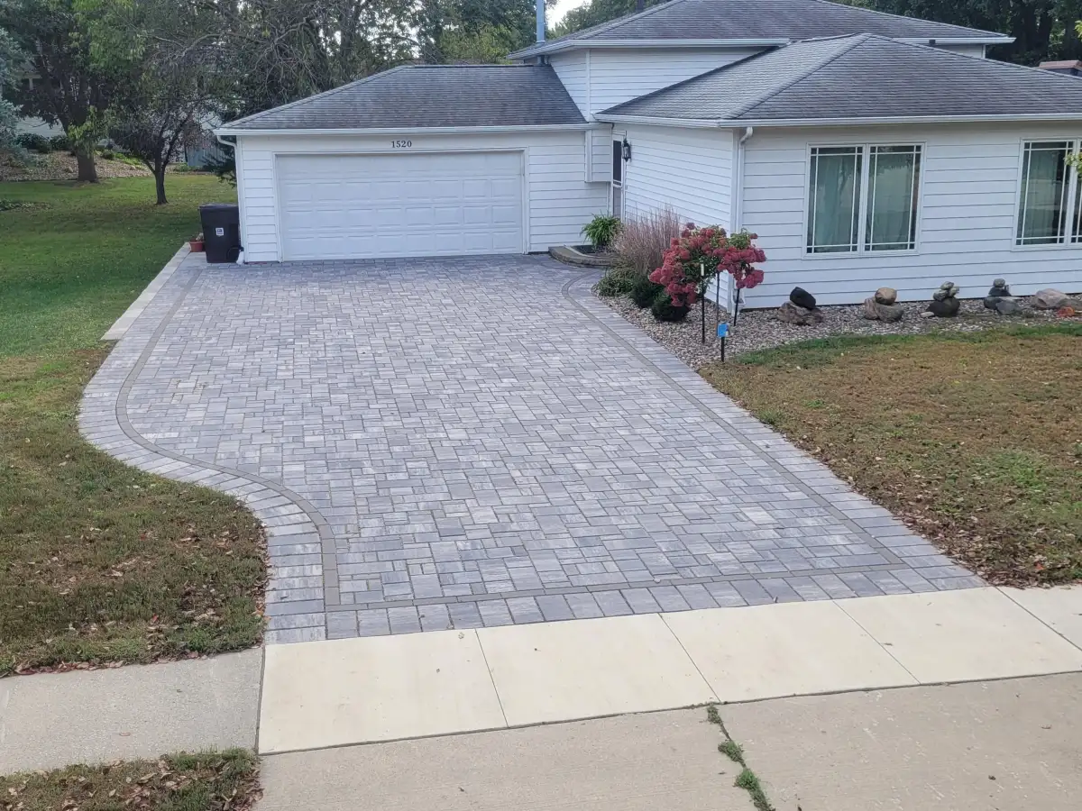 Gray paver driveway with dark border and fall plantings