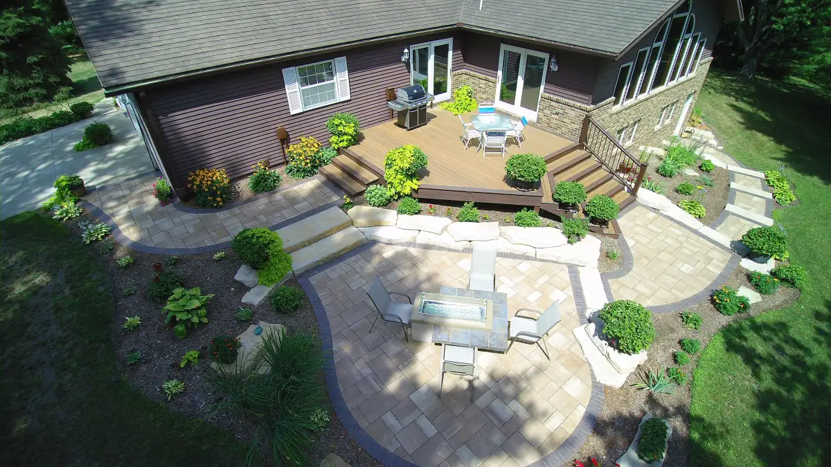 Aerial backyard with outdoor kitchen, fire table, and deck