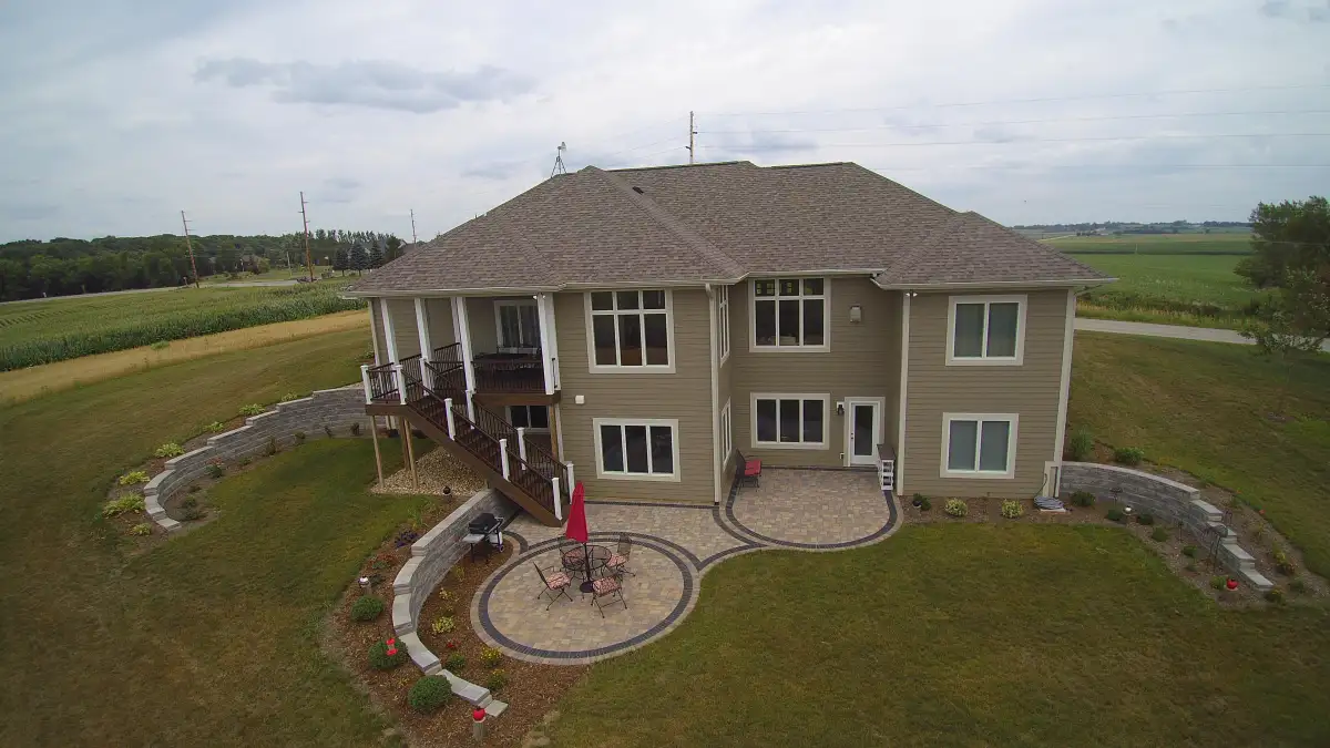 Aerial of circular paver patio with retaining walls and deck