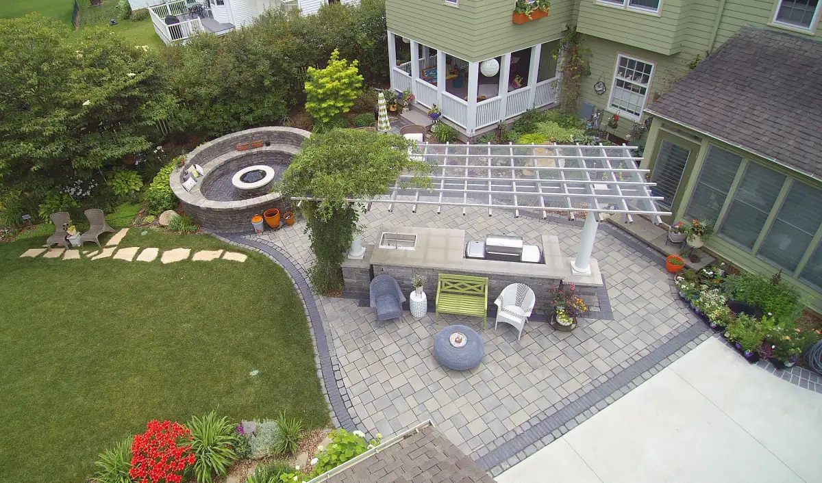 Aerial full backyard with outdoor kitchen, fire pit, and stepping stones