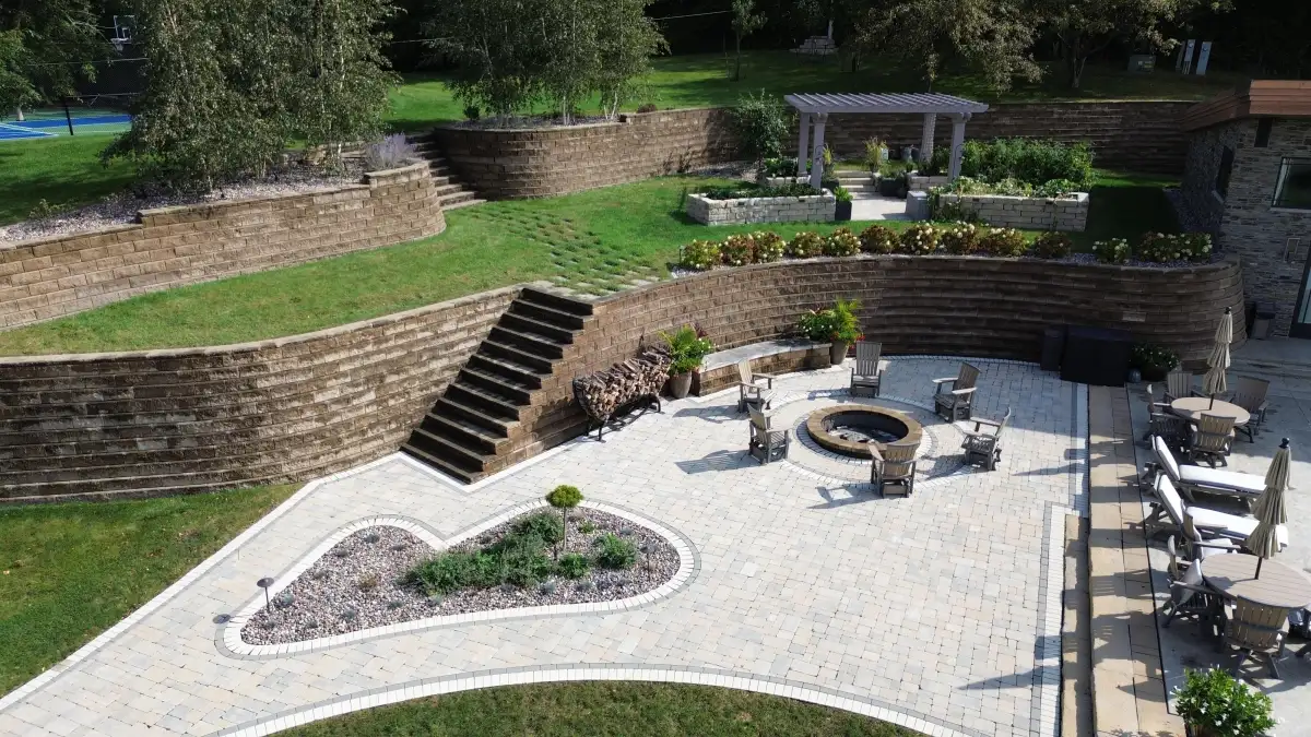 Tiered retaining walls with patio, fire pit, and pergola on slope