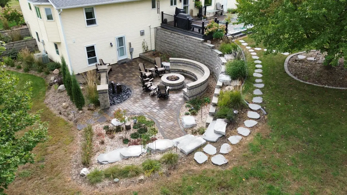 Hillside patio with curved retaining wall and natural stepping stone path