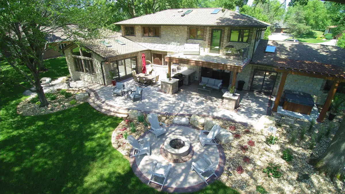 Stone-facade home with fire pit, outdoor dining, and pergola