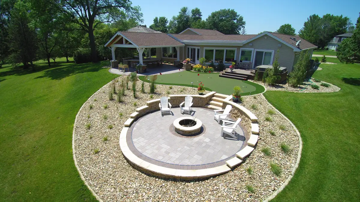 Open-gable pavilion with kitchen, fire pit circle, and putting green