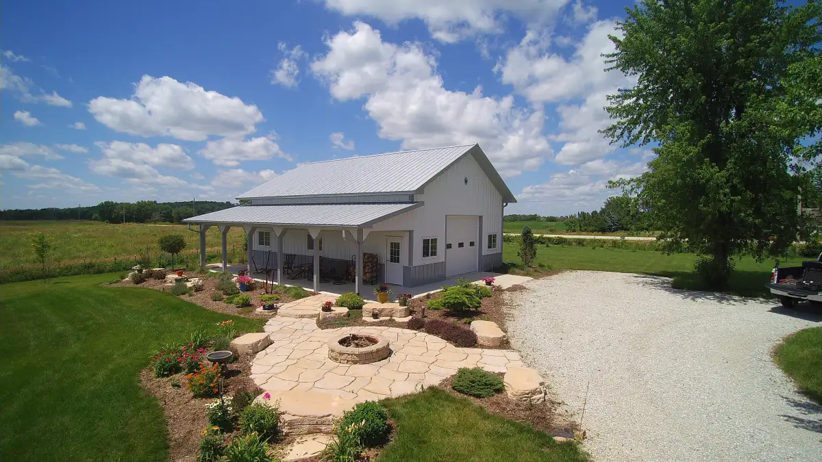 Rural flagstone patio with fire pit and colorful flower beds