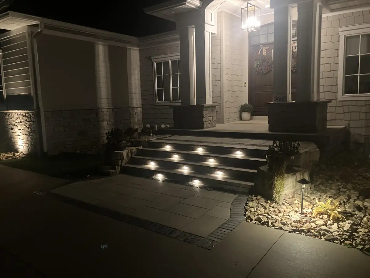 Night shot of front entrance with illuminated paver steps and path lights
