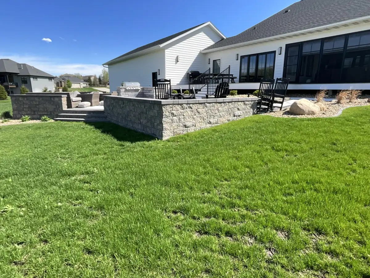 Raised patio with retaining wall and steps viewed from lawn