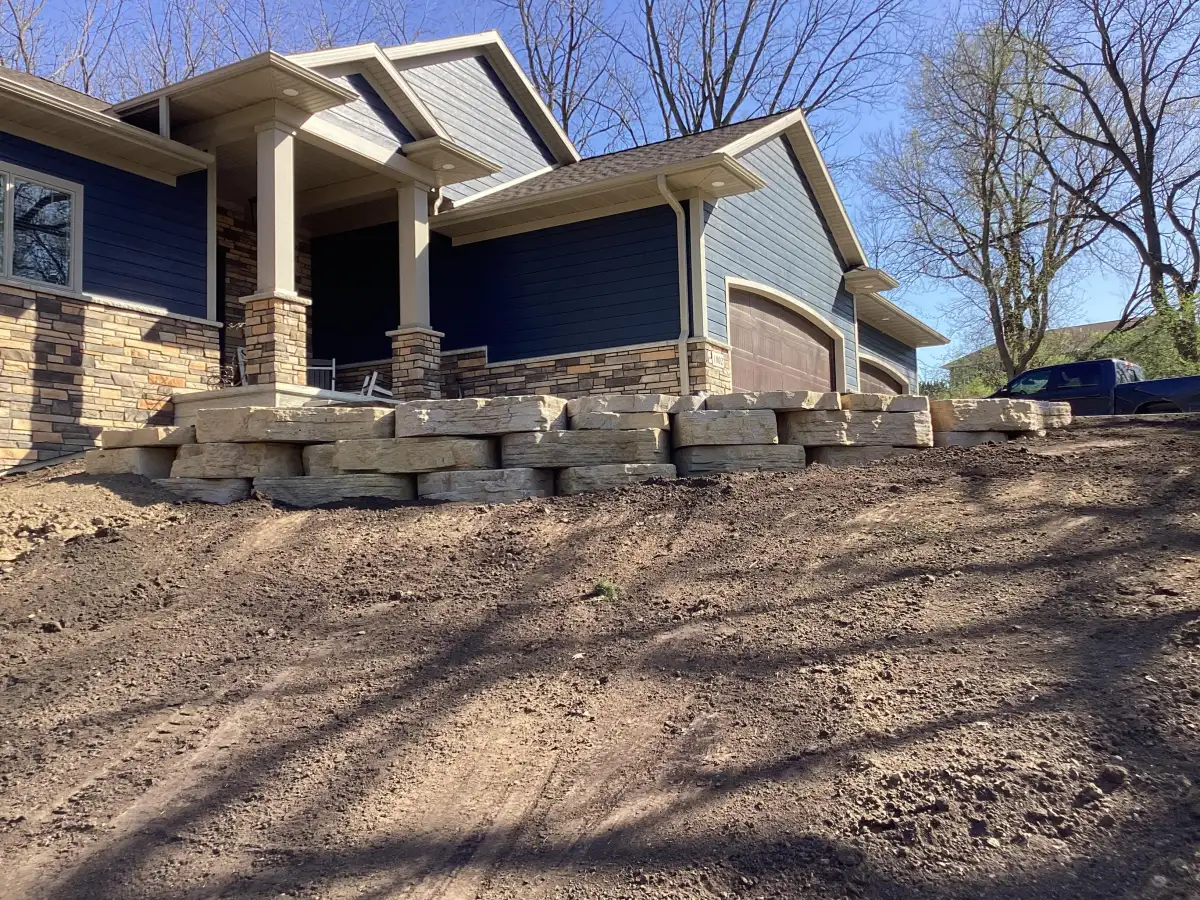 Completed retaining wall with landscaping and plantings in Iowa